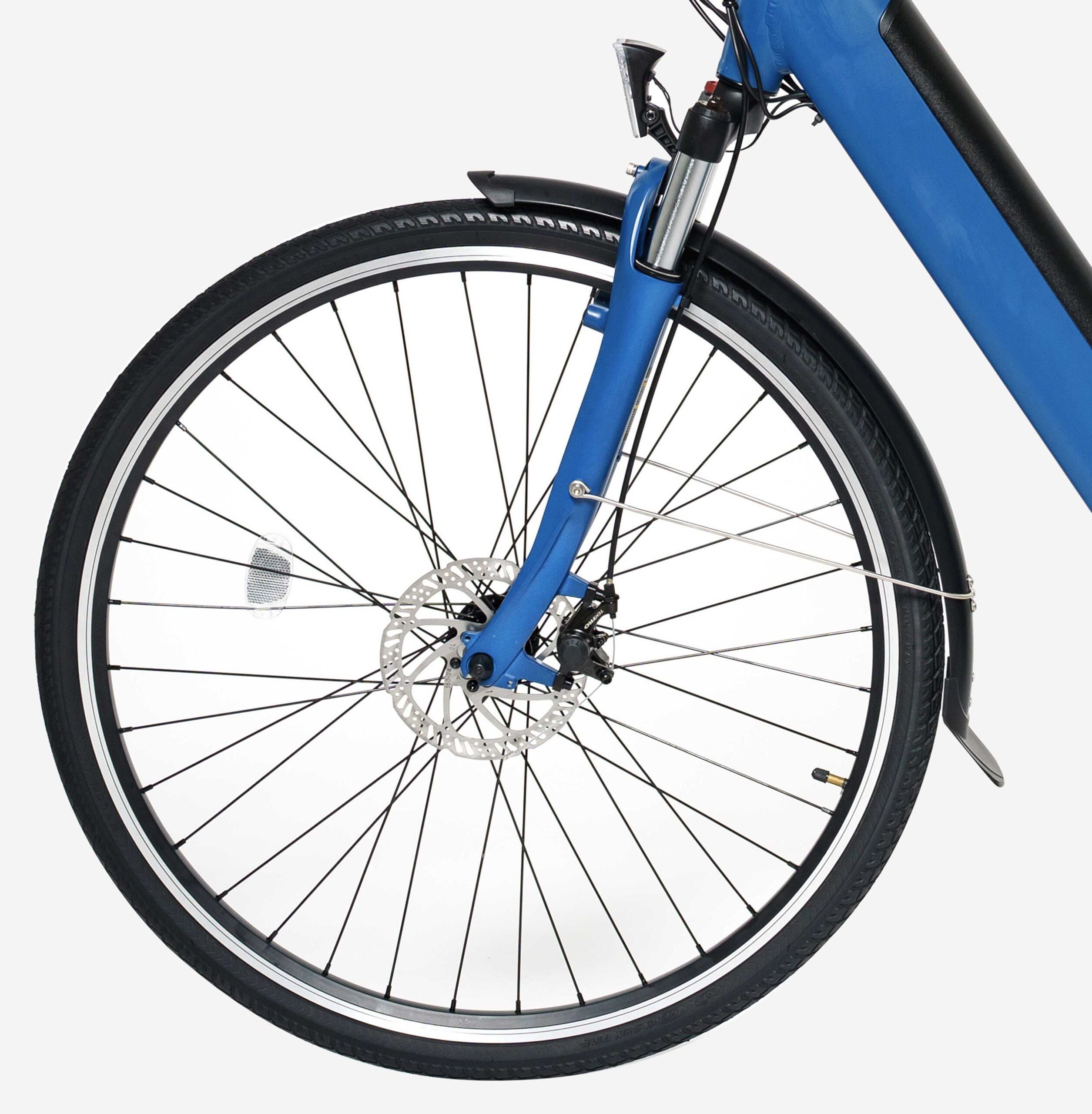 Vélo électrique Ariane bleu mat, de la roue avant, du côté gauche, zoom sur les pneus renforcés, les freins à disque et la fourche suspendue